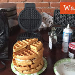 How can you tell if the waffle iron is hot enough to start baking the waffle?