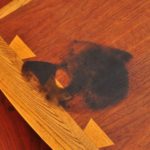 How does bleach remove water stains from wood?