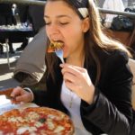 Is it rude to eat pizza with your hands in Italy?