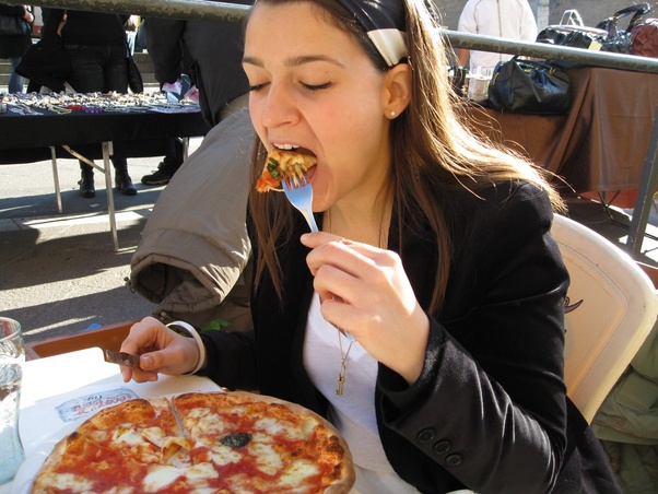 Is it rude to eat pizza with your hands in Italy?