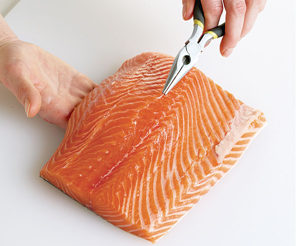How do you remove bones from fish before cooking?