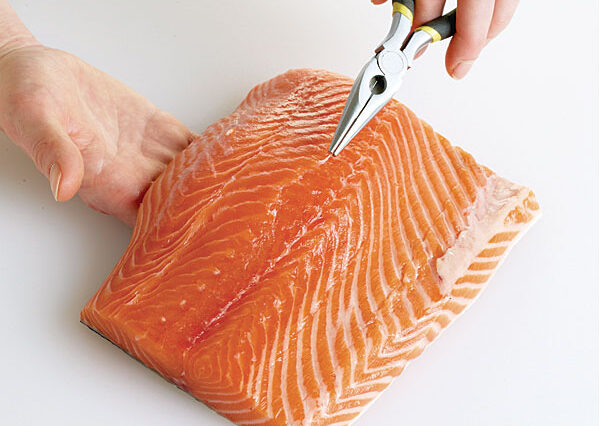 How do you remove bones from fish before cooking?