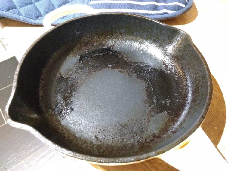 How do you remove burnt food from a cast iron pan?