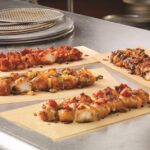 What comes on Domino's specialty chicken?