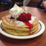 What is the garnish for New York Cheesecake pancakes at IHOP?
