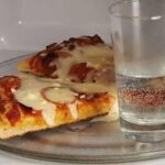 Why do you put a cup of water in the microwave with pizza?